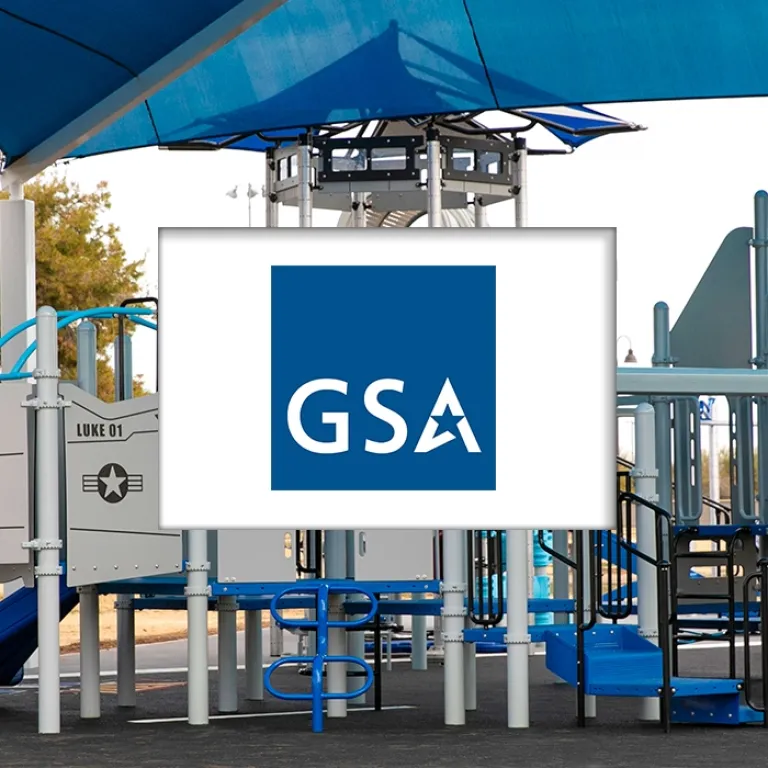 Playground with blue shade structure, slide, and climbing equipment.