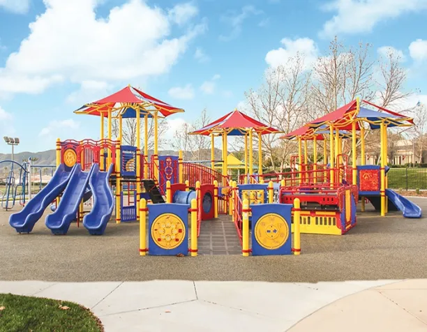 Colorful playground with slides, ramps, and shade structures under a bright sky.