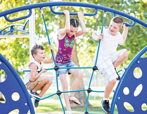 Three children climbing a blue rope net structure on a sunny day.