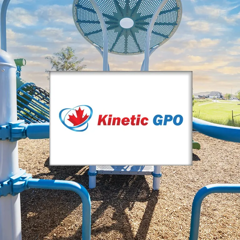 Playground equipment with blue structures and wood chip surfacing under a partly cloudy sky.